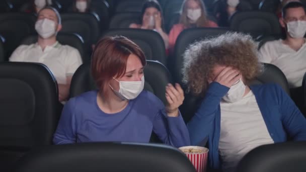 Casal enxugando lágrimas assistindo comédia no cinema. — Vídeo de Stock