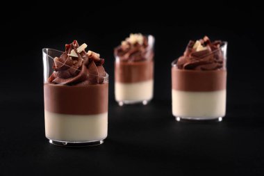 Siyah üzerine izole edilmiş katmanlı çikolatalı panna cotta..