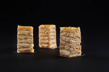 Kremalı pasta dilimleri, siyah üzerine izole edilmiş beyaz elma tatlısı..