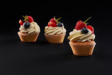 Böğürtlenli lezzetli kekler, siyah üzerine izole edilmiş..