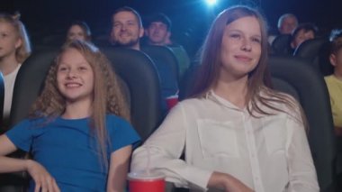 Küçük kız kardeşi sinemada gülen genç kız..