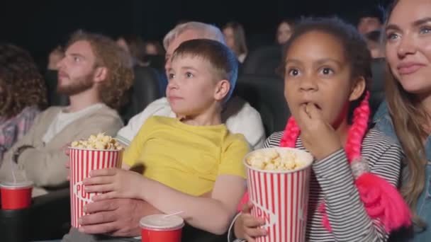 Madre con un niño africano de rodillas en el cine. — Vídeo de stock