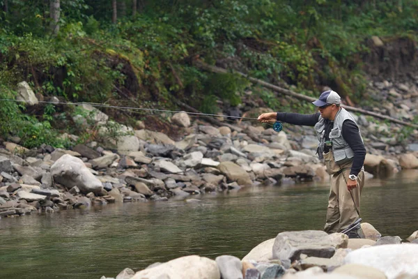 Pescador de pie en el río y la captura de peces en hoo — Foto de Stock