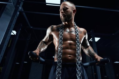 Spor salonunda paralel barlarda poz veren adam..