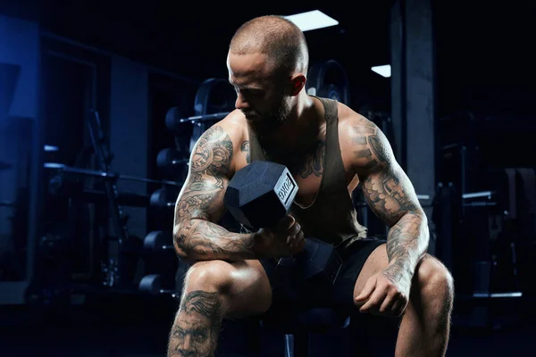Musculoso deportista construyendo bíceps con mancuerna. — Foto de Stock