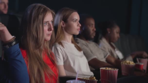 Multiraciala vänner äter popcorn på bio. — Stockvideo