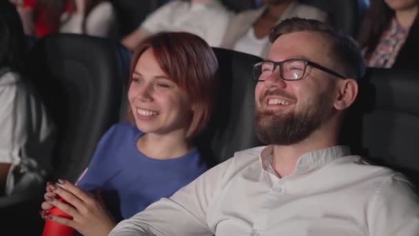 Смеющаяся пара наслаждается комедией в кино. — стоковое видео