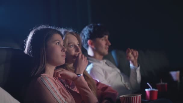Кавказские друзья едят попкорн в кино. — стоковое видео