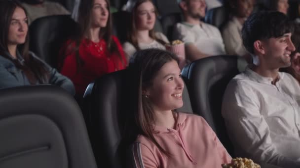 Público jovem assistindo filme engraçado no cinema. — Vídeo de Stock