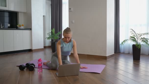 Mulher ativa assistindo vídeo fitness no laptop — Vídeo de Stock