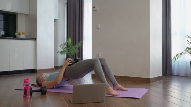 Mulher em máscara usando halteres durante o treino doméstico — Vídeo de Stock