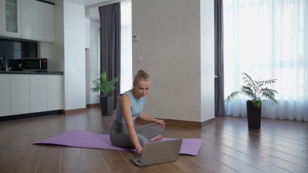 Woman using laptop for workout at home — Αρχείο Βίντεο