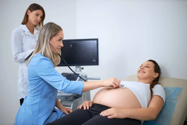 Arzt macht Diagnose mit Stethoskop für Schwangere — Stockfoto