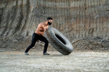Kaslı vücutlu, geniş lastikli aktif bir adam.