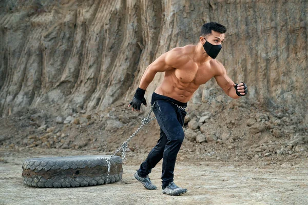 Muskulös man tränar utomhus med däck — Stockfoto