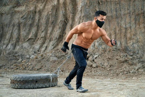 Hombre musculoso haciendo ejercicio al aire libre con neumáticos — Foto de Stock