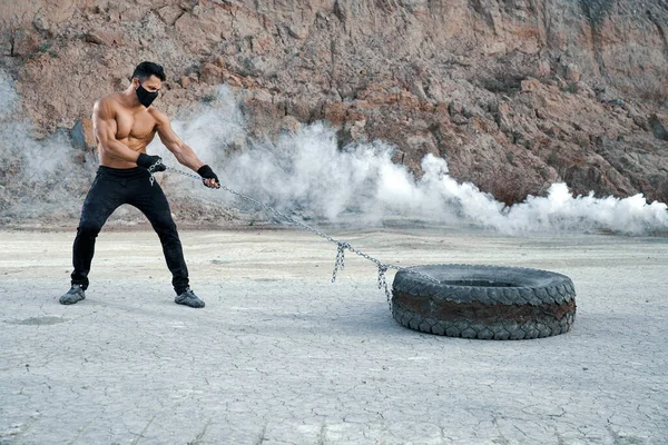 Hombre con brazos atléticos de entrenamiento corporal en hoyo de arena — Foto de Stock