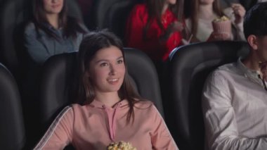 Genç kız sinemada komik bir film izliyor..