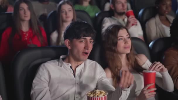 Jovem casal desfrutando de filme no cinema. — Vídeo de Stock