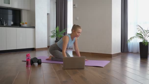 Mulher treinando em casa enquanto assiste tutorial no laptop — Vídeo de Stock