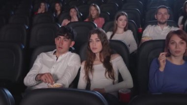Gergin seyirciler sinemada korku filmi izliyor..