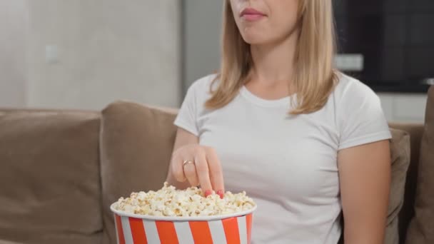 Крупным планом женщины едят попкорн и смотрят фильм — стоковое видео