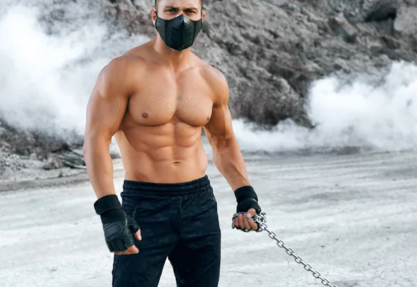 Bodybuilder i skyddsmask stående vid sandstenbrott — Stockfoto