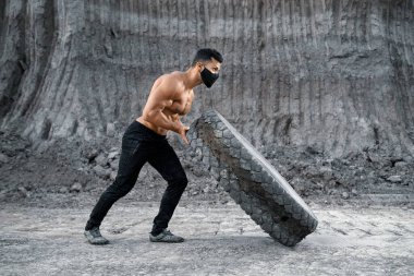 Geniş tekerlekli genç vücut geliştirici kolları çalıştırıyor.