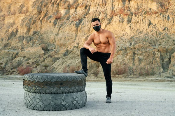 Atletisk kille i skyddsmask träning vid sand stenbrott — Stockfoto