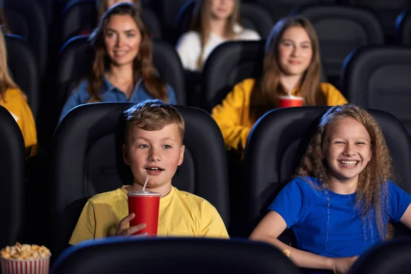 Crianças caucasianas curtindo desenhos animados no salão de cinema. — Fotografia de Stock