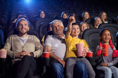 Büyükbabam ve torunum sinema salonunda çizgi film izliyorlar..
