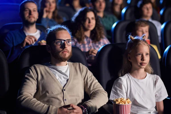 Brother and younger sister in movie theater.