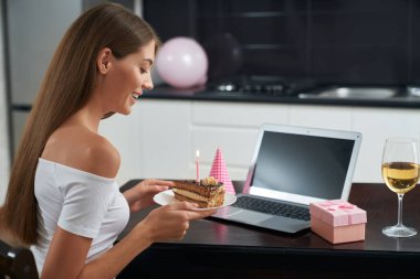 Doğum günü pastalı kadın evde tek başına oturuyor.