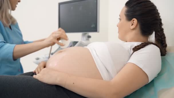 Kobieta w ciąży leżąca w klinice podczas zabiegu USG — Wideo stockowe