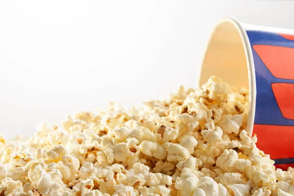 Verstreutes Popcorn aus einer großen gestreiften Schachtel. — Stockfoto