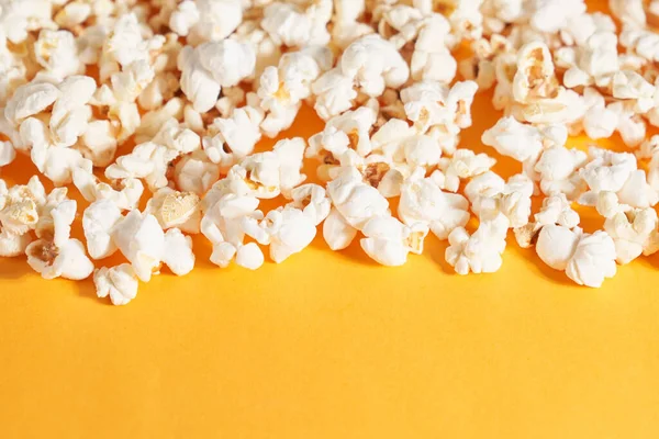 Leckeres ordentlich gefaltetes Popcorn auf orangefarbenem Hintergrund. — Stockfoto