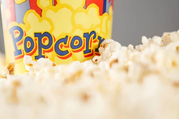 Leckeres Popcorn neben Pappbecher verschüttet. — Stockfoto