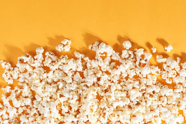 Leckeres Popcorn auf orangenem Hintergrund. — Stockfoto