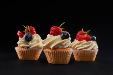 Böğürtlenli lezzetli kekler, siyah üzerine izole edilmiş..