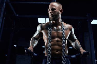 Spor salonunda paralel barlarda poz veren adam..