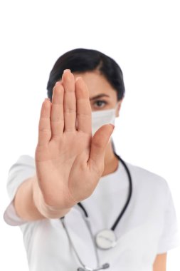 Tıbbi maskeli doktor, dur işareti gösteriyor.