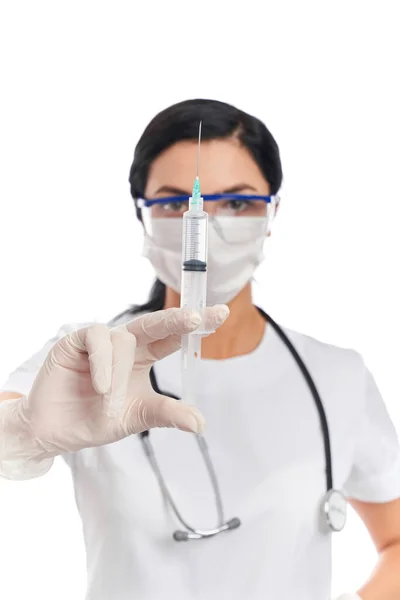 Компетентный врач в маске держит шприц с инъекцией — стоковое фото