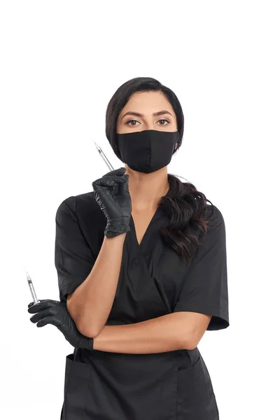 Esteticista en uniforme, mascarilla y guantes con jeringas — Foto de Stock