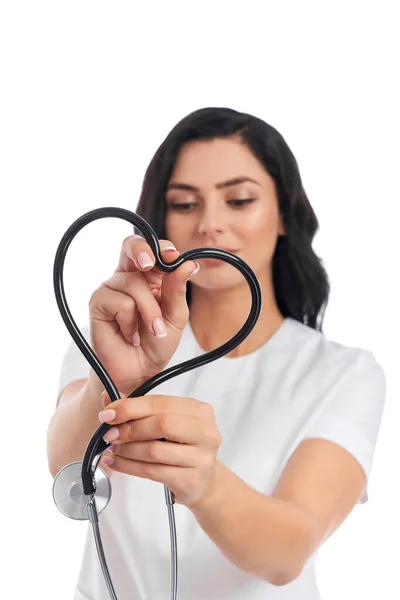 Médecin féminin positif tenant un stéthoscope en forme de cœur — Photo