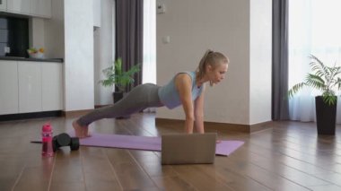 Atletik kadın evde kalas egzersizi yapıyor.