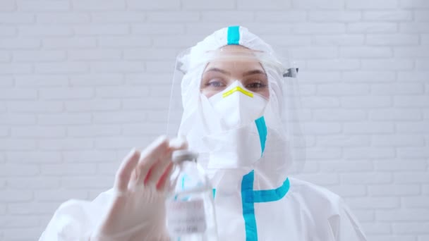 Медицинский работник в защитном костюме держит вакцину против коронавируса. — стоковое видео