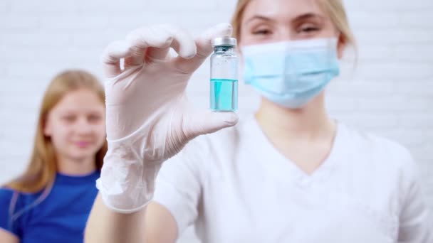 Медсестра держит вакцину от коронавируса для девочек. — стоковое видео