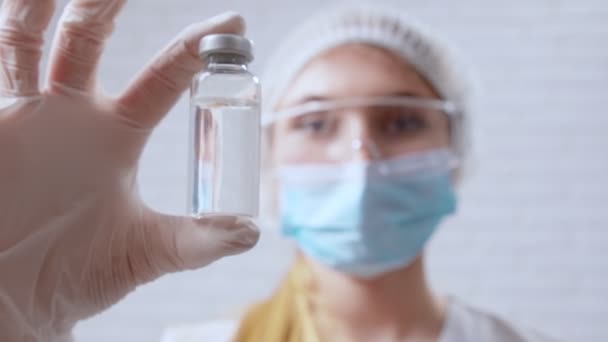 Медсестра держит вакцину от ковида-2019 в руках. — стоковое видео