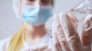 Koruyucu maskeli hemşire koronavirüsten şırıngaya ilaç çeviriyor..