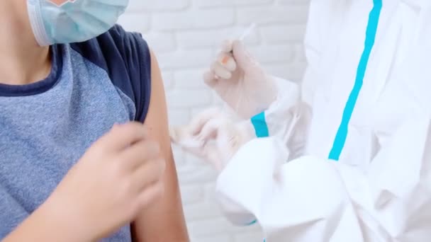 Infirmière en combinaison de protection donnant le coronavirus de vaccin pour la fille. — Video